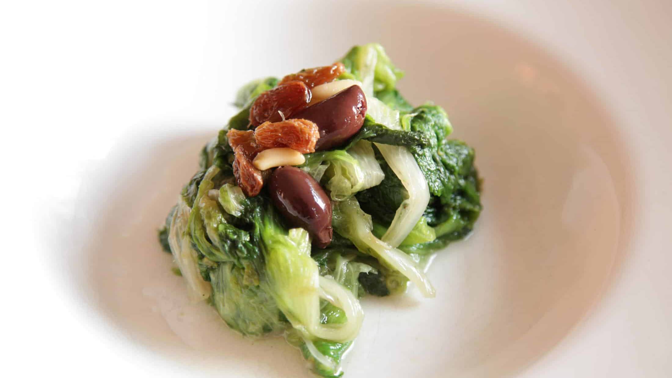 Endiviensalat mit Rosinen, Oliven und Pinienkernen